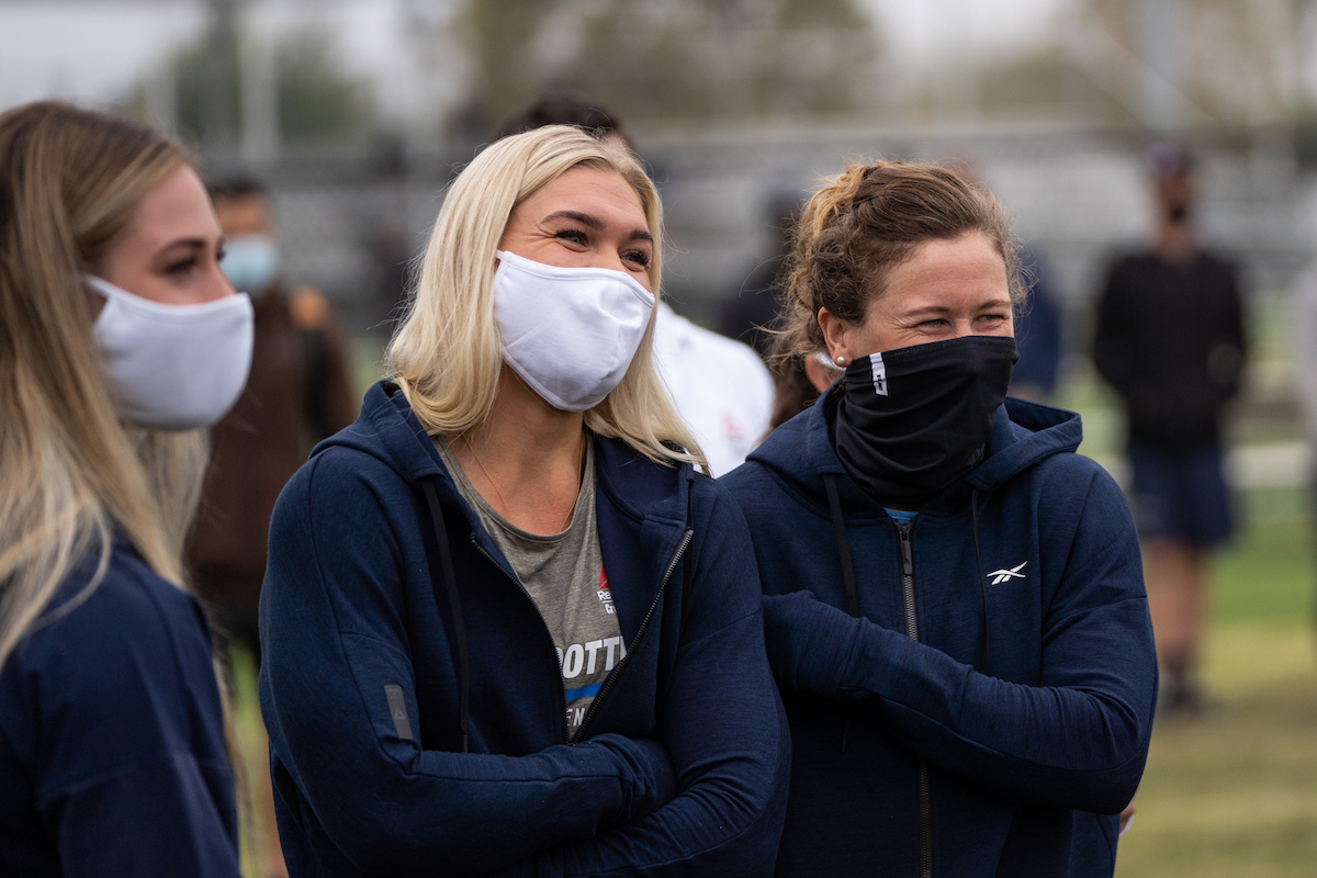 Women competitors wear masks along the sidelines