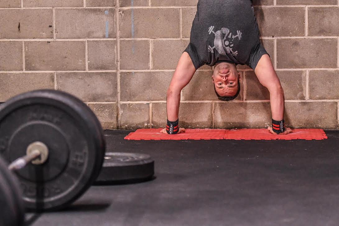 Inverted athlete pressing into HSPU