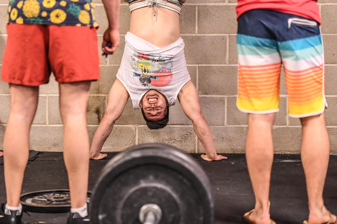 Athlete grimaces as he locks out a HSPU